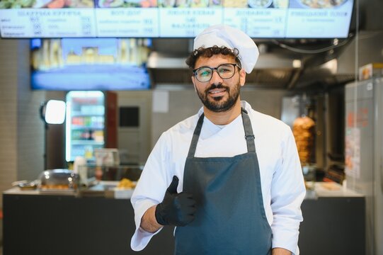Smiling chef gesturing thumbs up in kebab restaurant