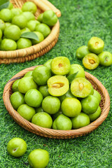 Fresh Green Plums in Wicker Baskets on Grass - Organic Stone Fruit Harvest