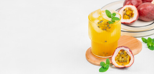 Fresh passion fruit juice with ice and mint on white background. Long banner format. copy space