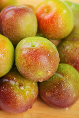 Fresh Cut Plums with Water Droplets Showing Red and Green Flesh Pieces in Close-up
