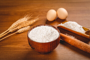 Fresh Wheat Flour Bowl with Baking Ingredients on Wooden Table