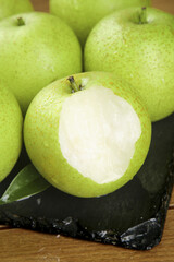 Fresh Green Dangshan Pears Display with Cut Pear Showing White Flesh on Slate Board