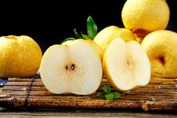 Fresh Dangshan Pears on Bamboo Mat - Golden Asian Pears with White Flesh Displayed on Dark Background