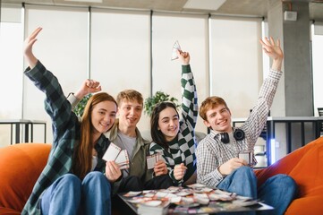Happy friends playing board game and having fun together