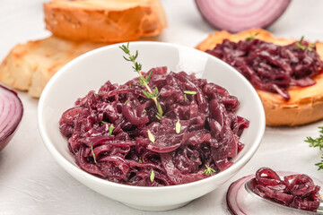 Caramelized red onion with fresh thyme in a white bowl, close-up view