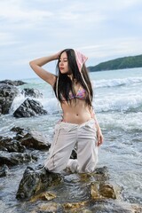 Woman Enjoys Sunny Day at Beach in Colorful Bikini by the Ocean