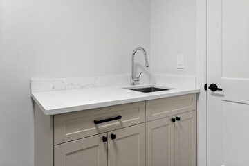 White sink and countertop with a black handle