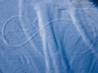 Aerial view of a large infinity symbol etched into the snow-covered landscape, creating a stark contrast between the white expanse and the defined lines, FÃ¼ssen, Bavaria, Germany.