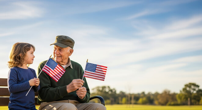 Veterans Day celebrated with an elderly veteran and a child holding small American flags in bright sunshine.