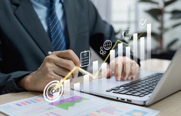 Businessman using virtual screen with cost reduction graph and down arrow representing business...