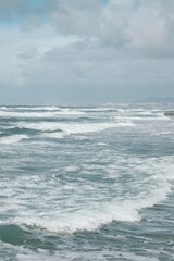 Fototapeta premium Scenic Ocean and Beach View in Costa da Caparica, Portugal, People Walking Along Shoreline at Sunrise or Sunset, Calm Waves and Atmospheric Coastal Landscape, Travel and Nature Photography