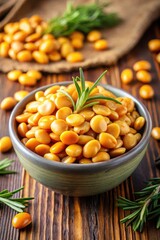 Photo of a closeup shot of a bowl filled with vibrant yellow lupini beans, garnished with fresh rosemary sprigs, set against a rustic wooden background with more beans scattered around