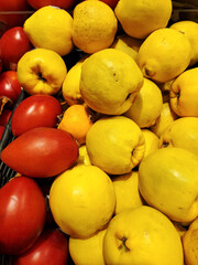 Close-up of yellow apples with red tomatoes