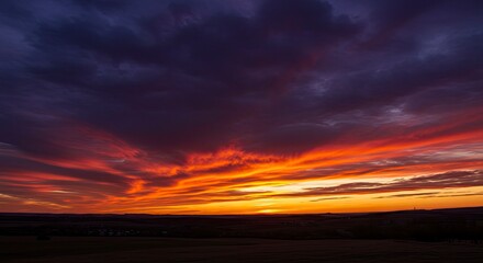 Fototapeta premium Fiery Sunset Over Rolling Hills: Dramatic Sky with Vivid Colors