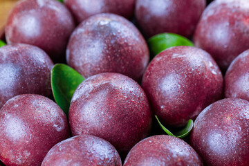 Fresh Red Plums with Water Droplets and Green Leaves - Ripe Stone Fruit Background