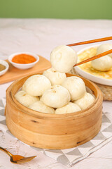 Fresh Steamed Xiaolongbao Dumplings in Bamboo Steamer Basket with Chopsticks