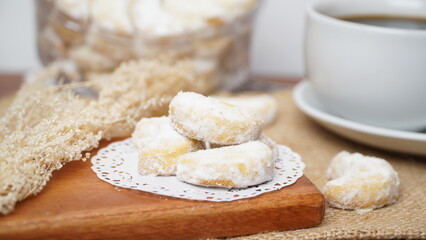Homemade Putri Salju cookies coated in powdered sugar, and with hot black coffee. Perfect for festive food promotions and design assets