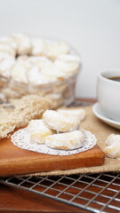 Homemade Putri Salju cookies coated in powdered sugar, and with hot black coffee. Perfect for festive food promotions and design assets