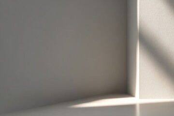 Obraz premium Soft light casts a diagonal shadow on a corner of a minimalist, light-gray room