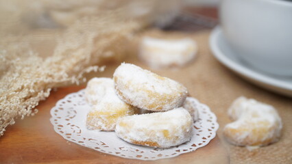 Homemade Putri Salju cookies coated in powdered sugar, and with hot black coffee. Perfect for festive food promotions and design assets