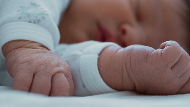 Close-up of a newborn baby&rsquo;s tiny fists, with the baby sleeping peacefully in the background-SD 480p