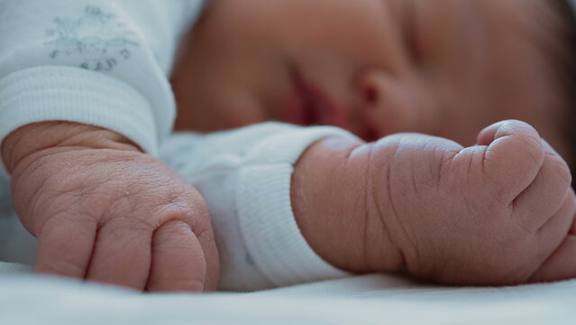 Close-up of a newborn baby&rsquo;s tiny fists, with the baby sleeping peacefully in the background-SD 480p