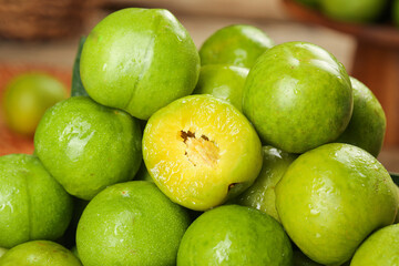 Fresh Green Sichuan Plums with Water Droplets - One Cut Half Showing Yellow Flesh