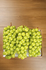 Fresh Green Grapes in Wooden Crate on Natural Wood Background - Healthy Organic Fruit Harvest
