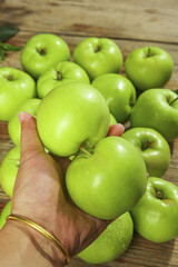 Fresh Ripe Green Apples from Shaanxi China - Hand Holding Organic Fruit on Wooden Background