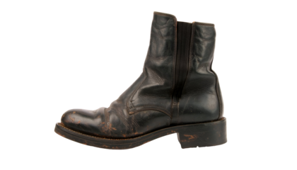 Black leather ankle boot with zipper, scuffed patina and durable work style on isolated background