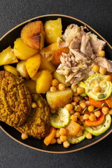 This hearty breakfast showcases a plate filled with baked sweet potatoes, carrots, zucchini, lentil cutlets, chicken breast