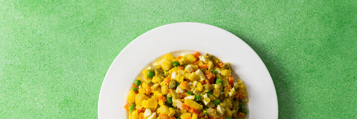 Colorful salad includes boiled egg, chicken breast, diced potatoes, carrots, and green peas mixed together and drizzled with olive oil, perfect for a healthy meal, banner