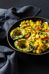 Healthy salad includes boiled egg, tender chicken breast, diced potatoes, vibrant carrots, fresh green peas, and creamy avocado topped with sesame seeds and drizzled with olive oil