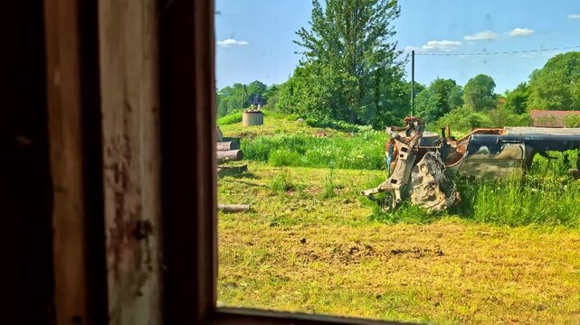 Person driving motorized walk-behind tractor (motoblock) with trailer in rural countryside