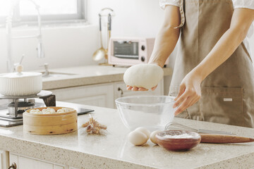 Baker kneading fresh dough with flour and ingredients in modern kitchen for homemade bread baking