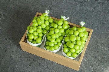 Fresh Green Grapes in Paper Bags Wooden Crate Market Display on Dark Slate Background