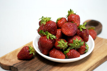 fresh strawberries in a bowl on a board