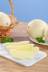 Fresh Cantaloupe Melon Slices on Wooden Table with Wicker Basket and Mint Garnish