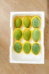 Fresh Green Mangoes in Protective Packaging Box Ready for Market Distribution