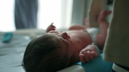 Mother tenderly caring for her newborn baby, dressing the baby in clothing, capturing an intimate moment of maternal care and love in a softly lit indoor environment-SD 480p