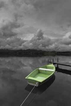 Storm clouds at sunset, a green rowing boat lashed to the wooden jetty, Hopfensee, Hopfen am See, near F&uuml;ssen, Ostallg&auml;u, Allg&auml;u, Bavaria, Germany
