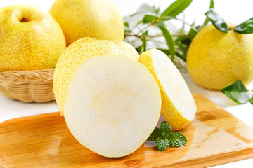 Fresh White Asian Pears Sliced on Wooden Board with Whole Pears and Green Leaves