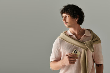 Stylish young man showcasing modern fashion in a minimalist studio environment with elegance
