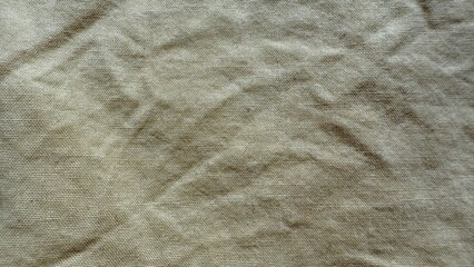 wrinkled beige linen fabric texture with natural folds and soft woven details for rustic wallpaper or editorial background