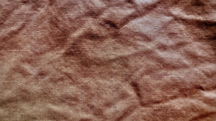textured brown fabric background with rustic woven surface and natural folds ideal for wallpaper banner or editorial illustration