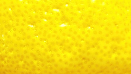 bright yellow lemon peel macro texture with dotted pores glowing surface detail vibrant citrus closeup for background or banner use