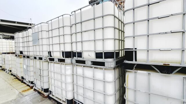 Stacked intermediate bulk containers on pallets create an industrial look, suitable for use in various industrial applications, representing storage solutions or logistical activities