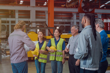 A group of engineers and staff members are discussing their work while working in a metal sheet and...