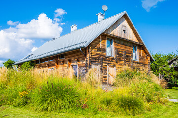 Rustic old wooden house on green meadow, Roztocze National Park, Poland