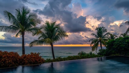 Obraz premium Tropical palms silhouetted against a vibrant sunset sky on a sandy beach